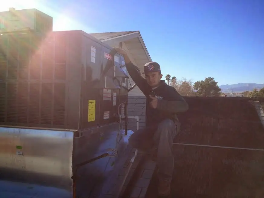 HVAC technician performing AC Tune-Up on a rooftop unit in Oakland Park